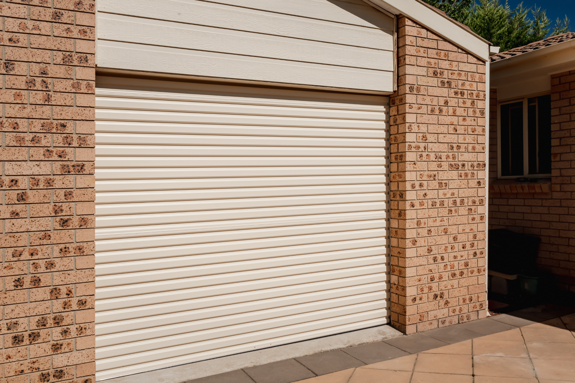 B&D Rollmasta roller garage door in cream on a brick home