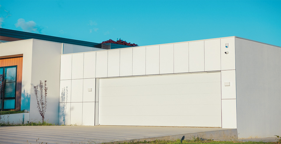 B&D Panelift Icon Nullarbor smooth sectional garage door in Surfmist on a white rendered modern home