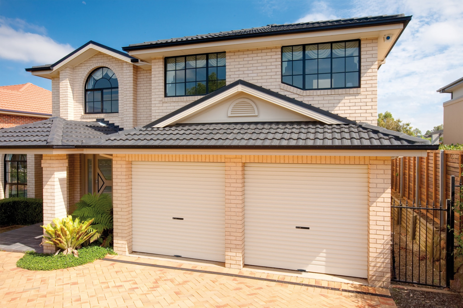 Two cream B&D roller garage doors on a double garage of a two-storey brick home