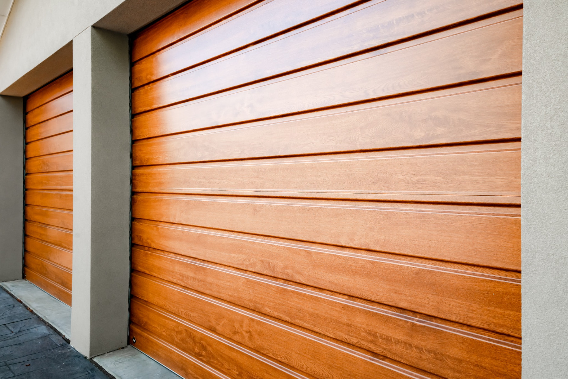 B&D product image of roller garage doors in a Golden Oak woodgrain finish, viewed on an angle