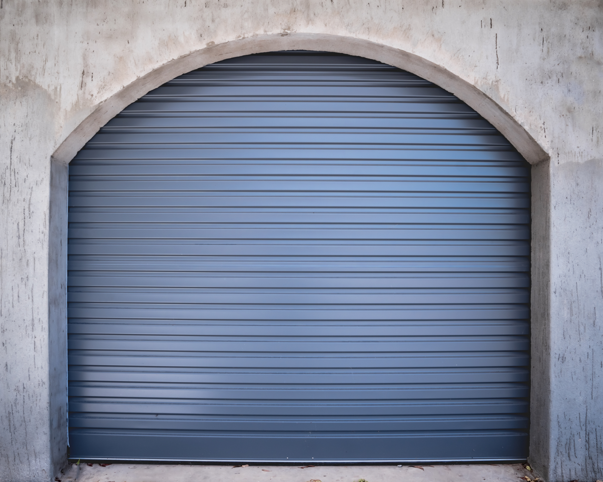 B&D Roll-A-Door Deluxe roller garage door in a Basalt finish fitted to an arched rendered opening