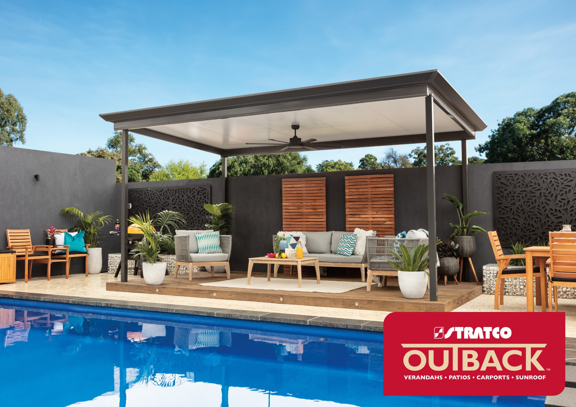 Stratco Outback flat-roof patio with Cooldek insulated roofing over a poolside deck — Stratco product imagery
