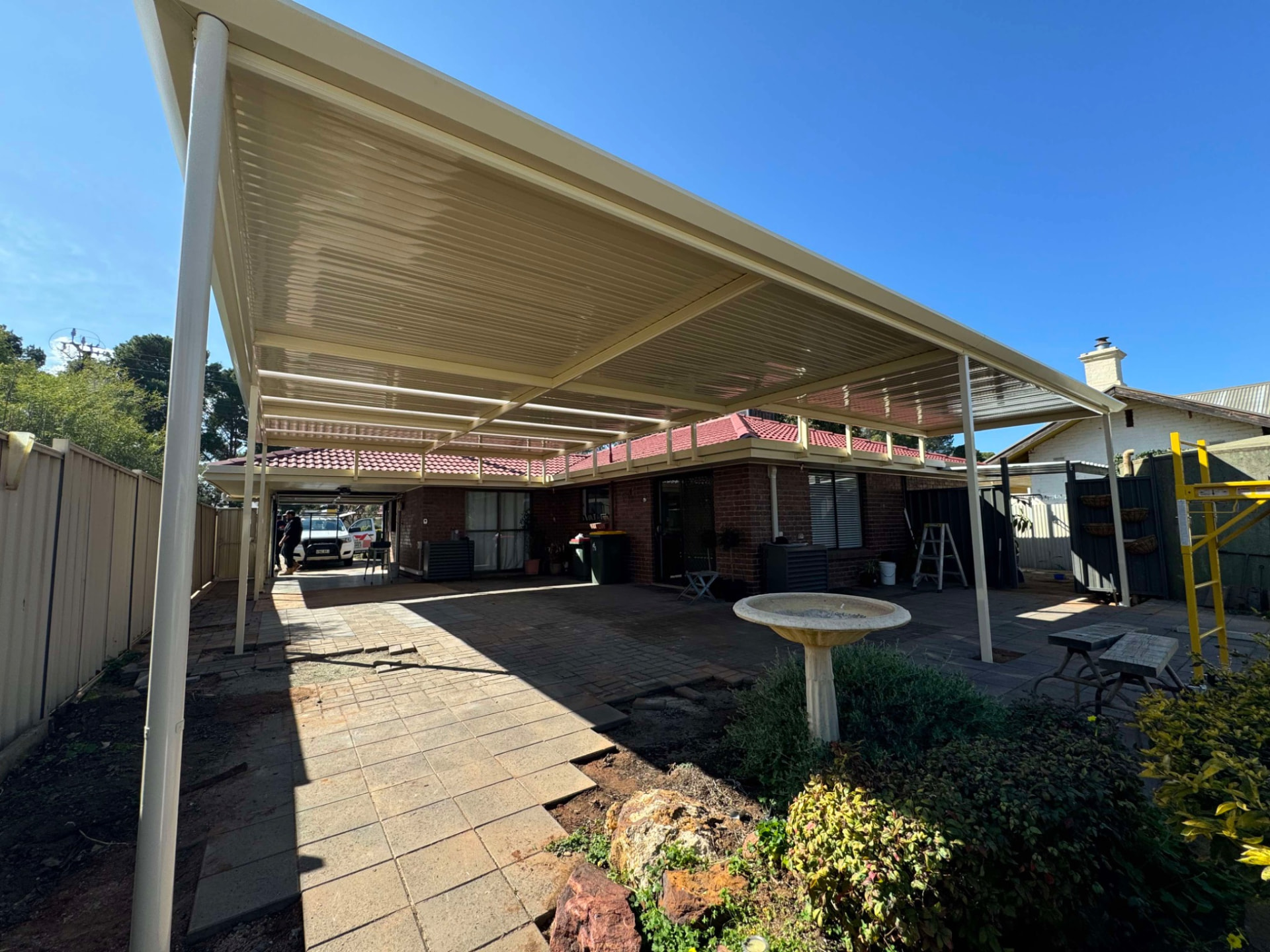 Wide exterior view of the completed Stratco Outback flat return patio looking back toward the brick home