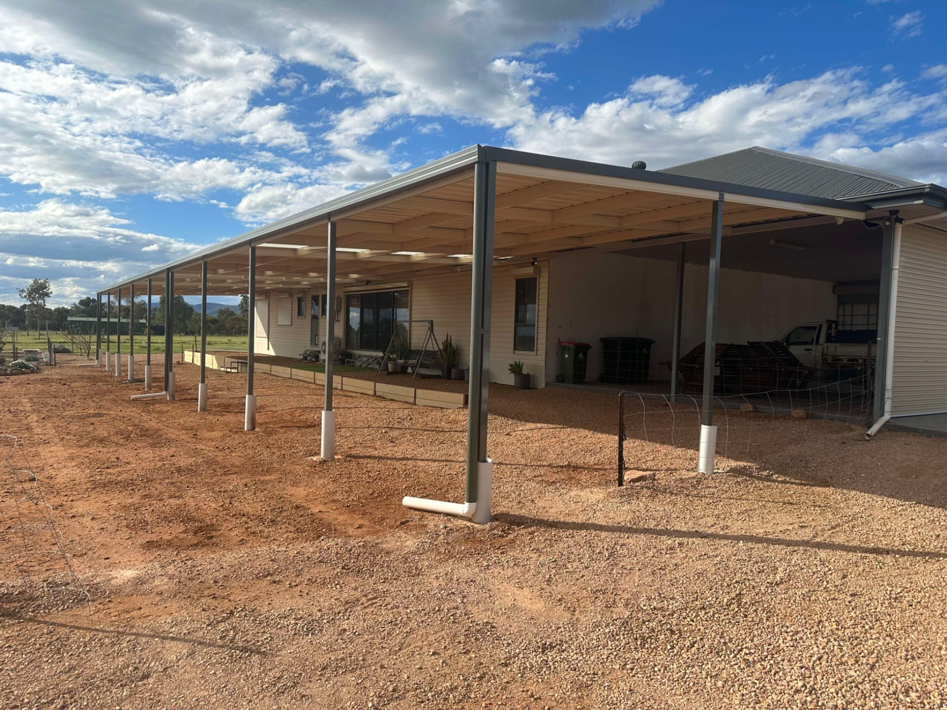 Long flat-roof Stratco Outback verandah on steel posts running along the side of a home