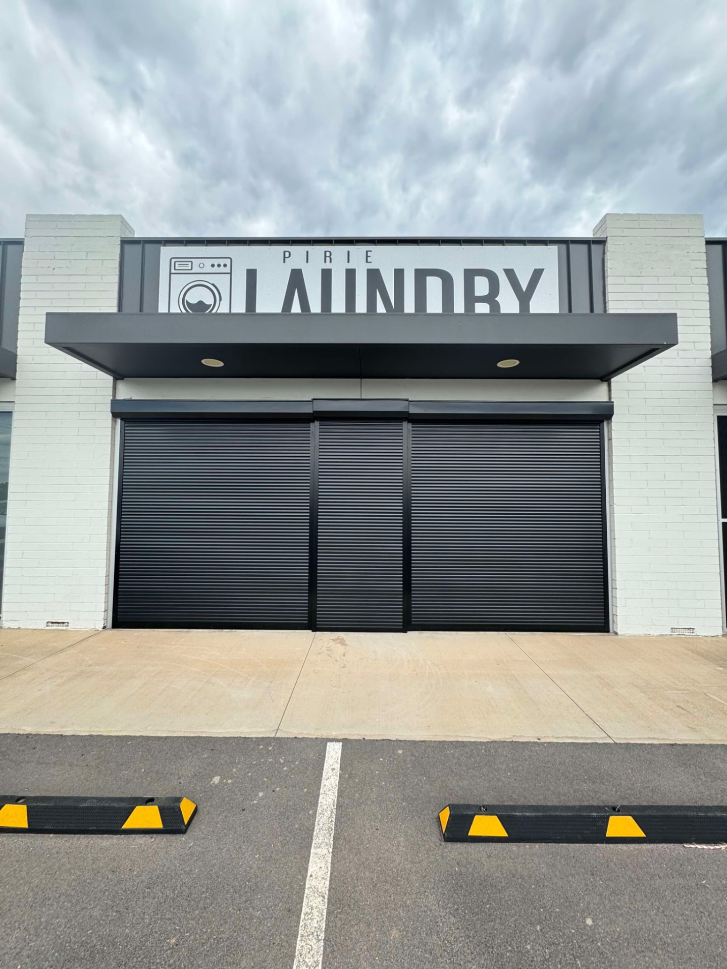Black roller shutters installed across a commercial shopfront entrance